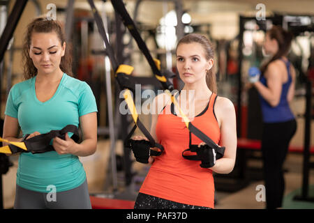 Womans making trx fitness excercise in gym Stock Photo