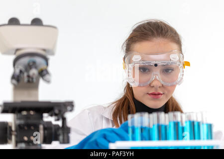 Scientists girl are mixing chemicals or doing some experiment to develop medicine in laboratory. Stock Photo