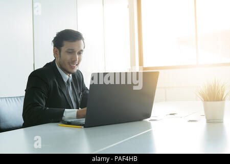 Young businessman or data engineer working and analyzing data with his laptop at office. Stock Photo