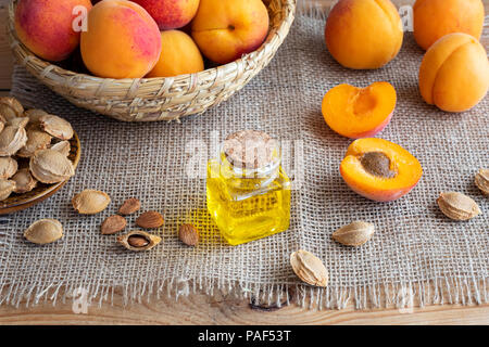 A bottle of apricot kernel oil with fresh fruit