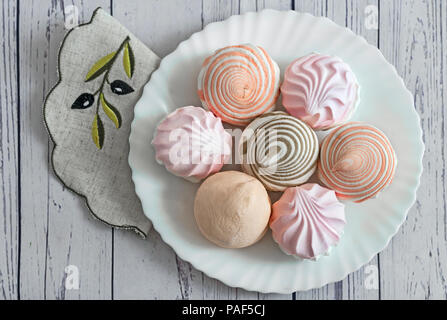 On a white plate is delicious marshmallows of different types. The view from the top. Stock Photo