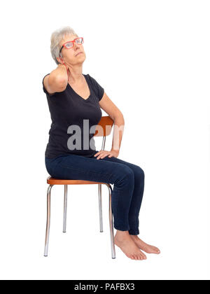 Grey haired, mature woman,seated, fully body with neck pain on white Stock Photo