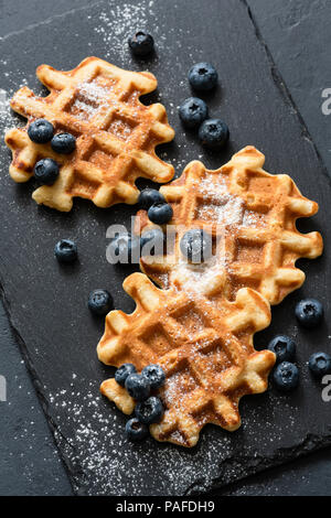 Belgian waffles served with blueberries on slate. Top view Stock Photo