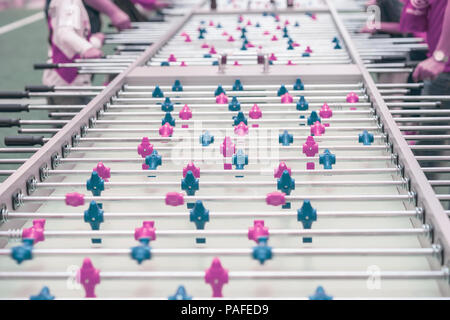 Table football game, soccer close-up and hands of people, selective focus. Soccer table with bright plastic players, foosball, shared leisure Stock Photo