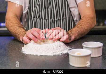Man preparing pizza dough on black granite table Stock Photo