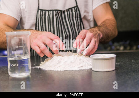 Man preparing pizza dough on black granite table Stock Photo