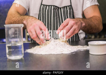 Man preparing pizza dough on black granite table Stock Photo