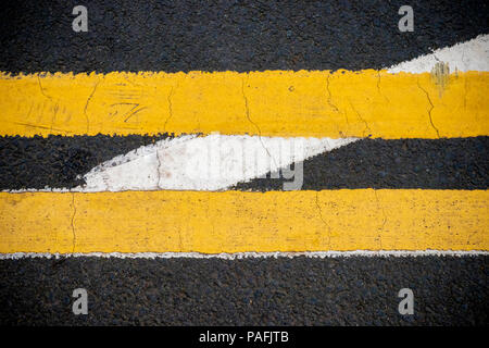 Two yellow lines and one white line on a road Stock Photo