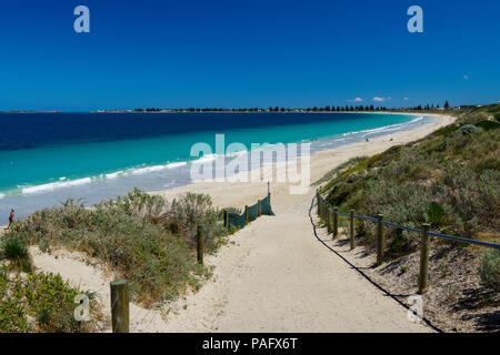 Sandy footpath leading down to deserted white sandy beach with clear blue water on summers day Stock Photo