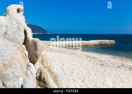 Fantastic views of rocky coast and  beautiful sandy beach on a sunny day with blue sky. Picturesque and gorgeous scene.Beautiful beach in Ouranoupolis Stock Photo