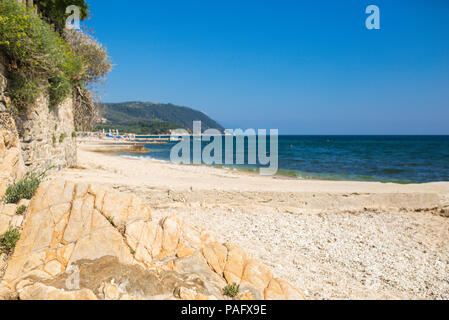 Fantastic views of rocky coast and  beautiful sandy beach on a sunny day with blue sky. Picturesque and gorgeous scene.Beautiful beach in Ouranoupolis Stock Photo