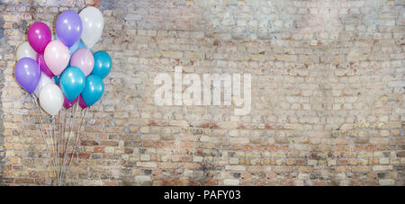 A lot of balloons at front of bricks wall. Stock Photo