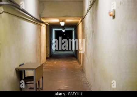 Long dark underground tunnel inside building. Light in the end of a tunnel. Abstract photo. Stock Photo