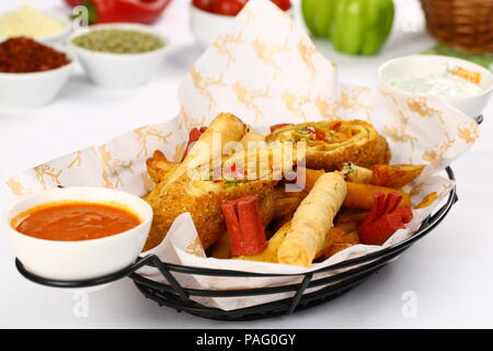Mixed appetizer of french fries, fried sasusage, fried zucchini, pastry, sigara borek with sauces Stock Photo