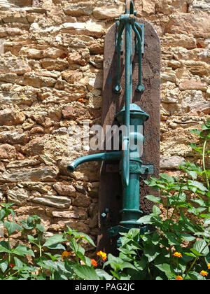 Antique metal water well pump in the courtyard and terrace of a wonderful french private home near to Magalas, Languedoc-Roussillon, France Stock Photo