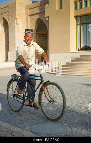 BUKHARA, UZBEKISTAN - JUNE 6, 2011: Portrait of unidentified Uzbek man rides the bycicle in Uzbekistan, Jun 6, 2011. 93% of Uzbek people consider that Stock Photo