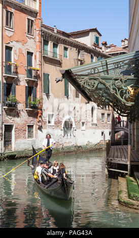 Gondola with tourists on Rio de la Veste behind La Fenice Theatre and Opera house with ornate wrought iron work, San Marco, Venice,  Veneto, italy Stock Photo