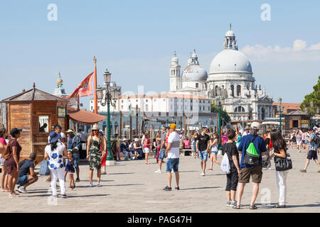 Tourists on Riva degli Schiavonni  in front of Basilica di Santa Maria della Salute in Piazetta San Marco, San Marco, Venice, Veneto, Italy Stock Photo