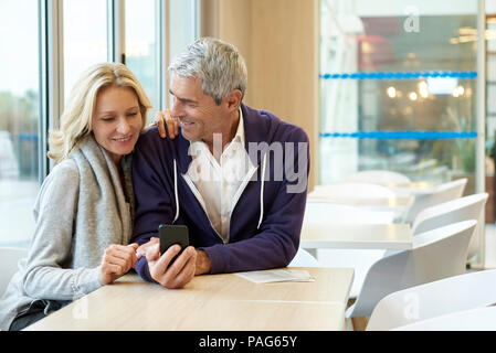 Couple using smart phone in cafŽ Stock Photo