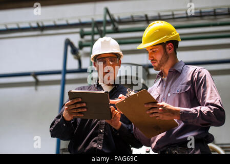 Factory workers discussing with each other in factory Stock Photo