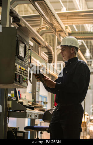 Factory worker using digital tablet in factory Stock Photo