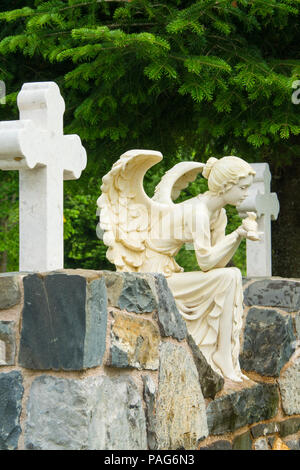 Marble sculpture of female angel sitting on the rock and holding a bird in her hands, Albania, Europe Stock Photo