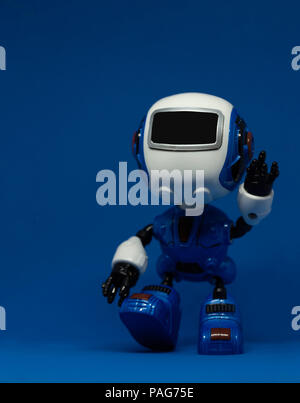 Robot toy waving left hand on blue background Stock Photo