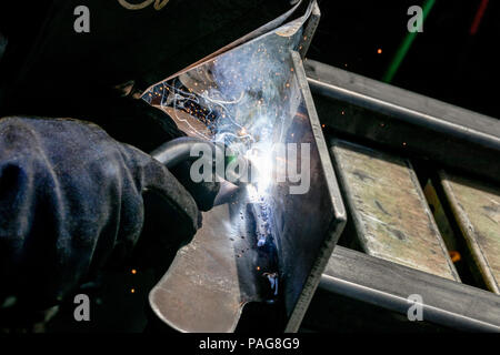 Man tig welding steel plate with brilliant bright white star burst blooms of lights Stock Photo