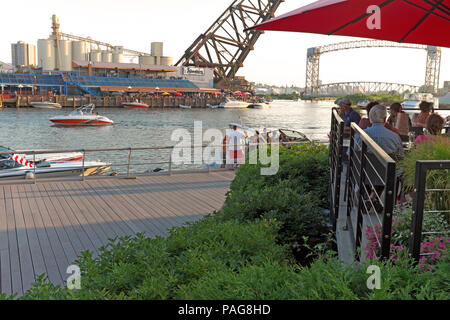 Al fresco dining along the Cuyahoga River in Cleveland, Ohio, USA is a summertime tradition bringing people to the riverside flats entertainment area. Stock Photo