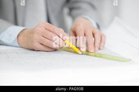 closeup . the engineer is making the drawing sitting behind his Desk Stock Photo