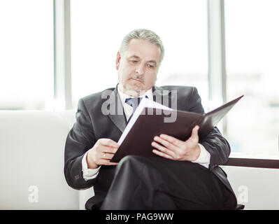 experienced lawyer reviews the documents with the terms of a new contract Stock Photo