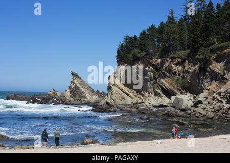 People on the shore near slanted rocks, at Shore Acres State Park near Coos Bay, Oregon, USA. Stock Photo