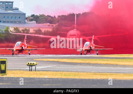 Royal Air Force RAF Red Arrows display team test their red smoke at the Farnborough International Airshow, FIA 2018, enveloping a Airbus A350 Stock Photo