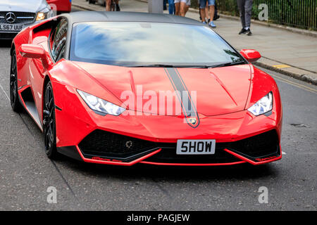 Sloane Street, London, UK, 20th July 2018. A red Lamborghini tries to steal the show. Supercars, high-performance and classic cars, as well as some characterful adaptions, line up and drive along Sloane Street for Supercar Sunday, which sees around 400 cars attending. The meetup is organised by Surrey Car Meet and on social media.