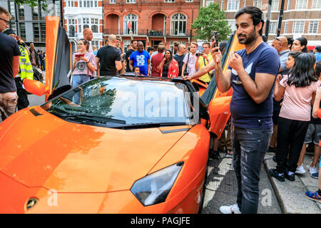 Sloane Street, London, UK, 20th July 2018. A red Lamborghini tries to steal  the show. Supercars, high-performance and classic cars, as well as some  characterful adaptions, line up and drive along Sloane Street for Supercar  Sunday, which sees around 400