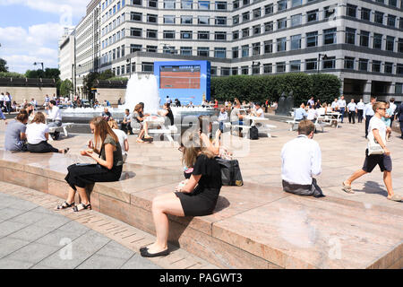London. UK. 23rd July 2018. City workers enjoy their lunchbreak in the summer sunshine in Cabot Square, canry Wharf with temperatures expected to reach 35C this week and the Met Office issues an Amber weather warning for parts of Britain affected by the ongoing heatwave Credit: amer ghazzal/Alamy Live News Stock Photo