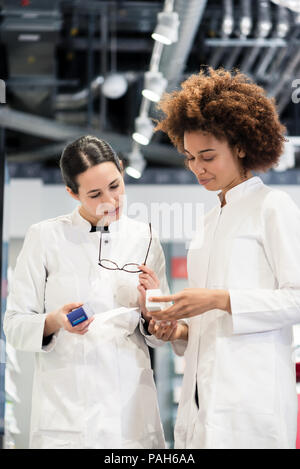 Reliable pharmacists analyzing a prescription and two different packages Stock Photo
