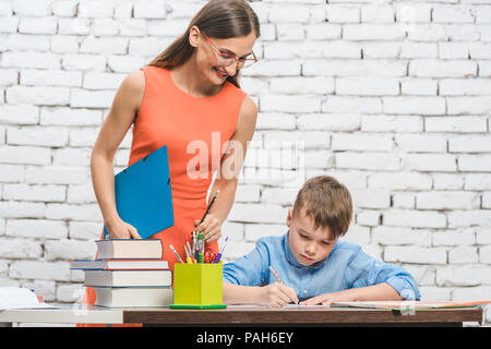 Teacher helping student with difficult task in school  Stock Photo