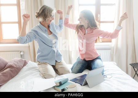 Mother and daughter working together giving high-five Stock Photo