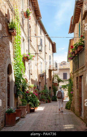 A Lady tourist strolling in one of the adjoining ways of the main street of Pienza (Tuscany - Italy). Stock Photo