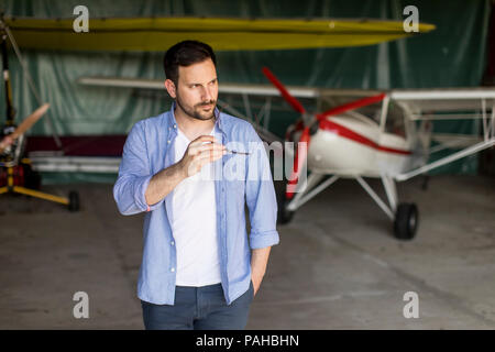 Handsome young pilot checking ultralight airplane before flight Stock Photo