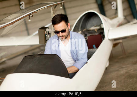 Handsome young pilot checking ultralight airplane before flight Stock Photo