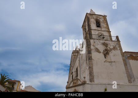 Weathered facade of a church of Sao Sebastiao in portuguese city Lagos, located on a hill. Cloudy sky. Lagos, Algarve, Portugal. Stock Photo