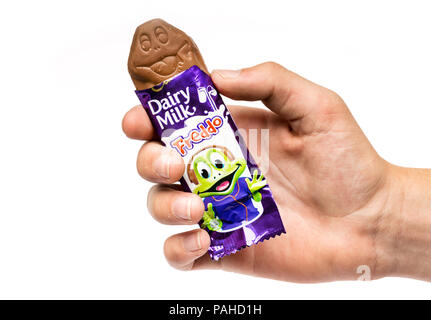 A boy holding a Cadbury Freddo chocolate bar against a white background Stock Photo