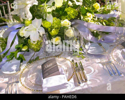 ALFRESCO LUXURY TABLE SETTING MENU Luxury alfresco table menu place setting in a sunny garden floral terrace outdoor formal seated silver service lunch reception event Stock Photo