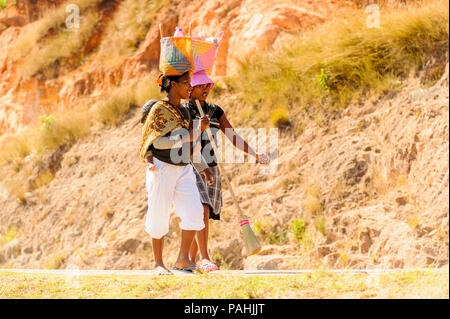 ANTANANARIVO, MADAGASCAR - JUNE 27, 2011: Unidentified Madagascar women walk and carry bags on their heads. People in Madagascar suffer of poverty due Stock Photo