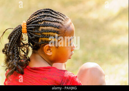 ANTANANARIVO, MADAGASCAR - JUNE 27, 2011: Unidentified Madagascar beautiful girl with african pigtails. People in Madagascar suffer of poverty due to  Stock Photo