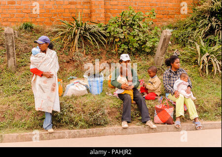 ANTANANARIVO, MADAGASCAR - JUNE 29, 2011: Unidentified Madagascar mothers with their children sitting on the ground.  People in Madagascar suffer of p Stock Photo