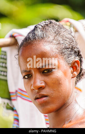 OMO VALLEY, ETHIOPIA - SEP 20, 2011: Portrait of an unidentified Ethiopian girl hanging the clothes to dry in Ethiopia, Sep.20, 2011. People in Ethiop Stock Photo