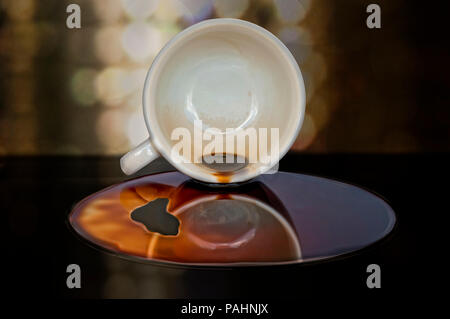 Overturned cup of coffee with puddle Stock Photo